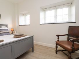 A bedroom with a bed, lamp, and chair at Pen Y Cefn in Pen Y Cefn