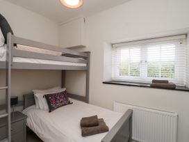 A bedroom with a bunk bed and a single bed at Pen Y Cefn