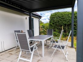 An outdoor dining area with a table and six chairs at Pen Y Cefn