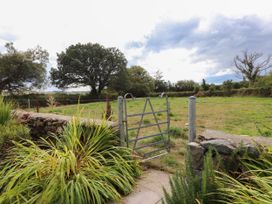An outdoor area with a gate leading to a grassy field at Pen Y Cefn in Pen Y Cefn