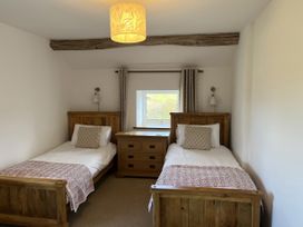 A bedroom with two beds and a dresser at The Stables At Cae Gwyn in Ruthin