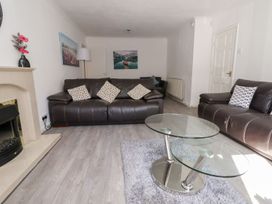 A living room with a sofa, table, and wall art at Castellolwg