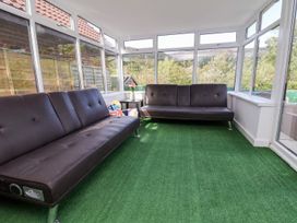 A conservatory with sofas and a table at Castellolwg