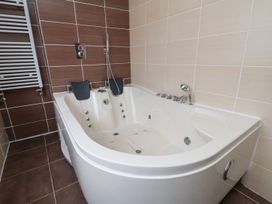 A bathroom with a bathtub and showerhead at Castellolwg