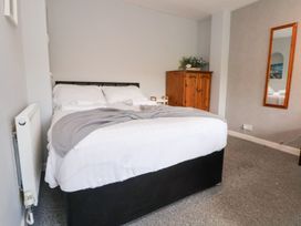 A bedroom with a bed and wardrobe at Castellolwg