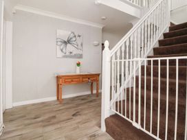 A hallway with a console table and staircase at Castellolwg