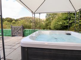 A hot tub under a canopy with a view of greenery at Castellolwg