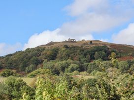 A hill with ruins and trees at Castellolwg