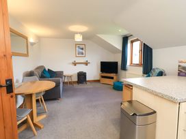 A living room with a sofa and television at High Dow Crag in Coniston