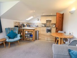 A kitchen with wooden cabinets and appliances at High Dow Crag in Coniston
