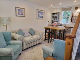 A living room with a sofa and dining area at Millgate Cottage in Conwy