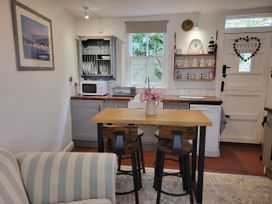 A kitchen with a wooden table and stools at Millgate Cottage in Conwy
