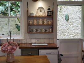 A kitchen with a wooden worktop and a window at Millgate Cottage in Conwy