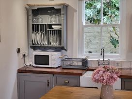 A kitchen with a microwave and sink at Millgate Cottage in Conwy