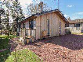 A wooden house with a garden and decking at Barn Owl in Otterburn