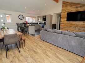 A living room with a sofa and dining area at Barn Owl in Otterburn