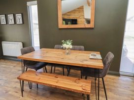A dining room with a wooden table and chairs at Barn Owl in Otterburn