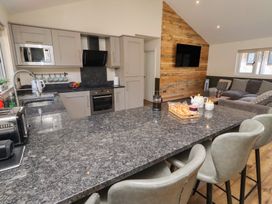 A kitchen with cabinets, countertop, and seating at Barn Owl in Otterburn