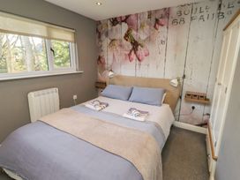 A bedroom with a bed and wall art at Barn Owl in Otterburn