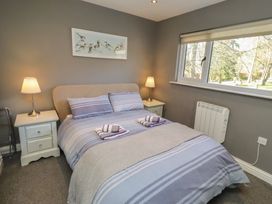 A bedroom with a bed and bedside tables at Barn Owl in Otterburn