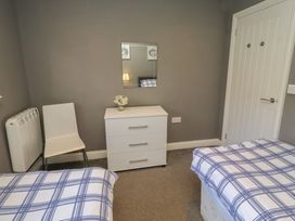 A bedroom with two beds and a dresser at Barn Owl in Otterburn
