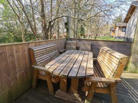An outdoor seating area with wooden furniture at Barn Owl Otterburn