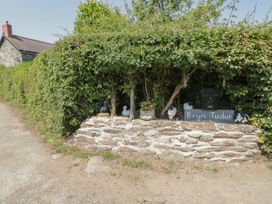 A stone wall with a plant pot a mailbox and animal figurines under bushes at Bryn Tudur in Henryd near Conwy