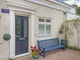 A blue door with a blue bench outside and plants in pots at Barwood View in Torquay