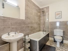 A bathroom with a sink bathtub shower toilet and a framed picture at Barwood View in Torquay