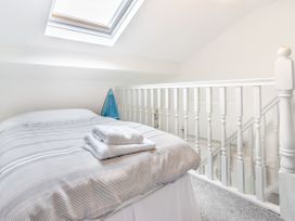 A bedroom with a bed and towels on it under a skylight by a white railing at Barwood View in Torquay