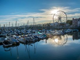 A marina with boats docked and a Ferris wheel in the background at Barwood View in Torquay