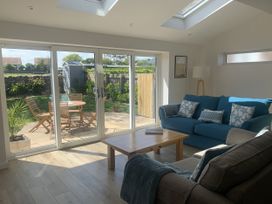 A living room with a coffee table and sliding doors leading to a garden at The Nest in Beadnell