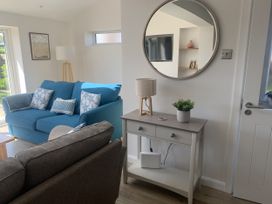 A living room with a blue sofa and a side table at The Nest in Beadnell