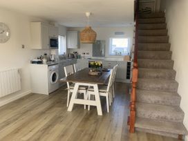 A kitchen with a dining table and washing machine at The Nest in Beadnell