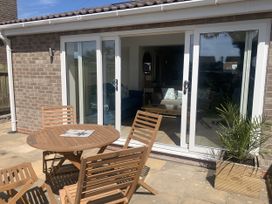 An outdoor patio with a table and chairs at The Nest in Beadnell
