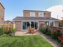 A garden with a table and chairs at The Nest in Beadnell