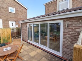 A garden with a table and chairs at The Nest in Beadnell