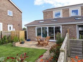 A garden with a table and chairs at The Nest in Beadnell