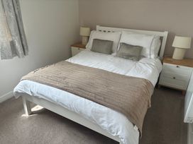 A bedroom with a bed and bedside tables at The Nest in Beadnell