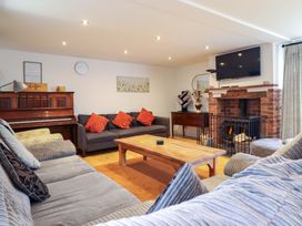A living room with a piano, sofa, coffee table, and fireplace at Bwthyn Y Bugail (Shepherd's Cottage) Pedairffordd near Llanrhaeadr-Ym-Mochnant