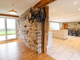 A kitchen with stone walls and dining area at Bwthyn Y Bugail (Shepherd's Cottage) Pedairffordd near Llanrhaeadr-Ym-Mochnant