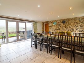 A dining room with a long table and chairs at Bwthyn Y Bugail (Shepherd's Cottage) Pedairffordd near Llanrhaeadr-Ym-Mochnant