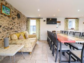 A dining room with a large table and sofa at Bwthyn Y Bugail (Shepherd's Cottage) near Pedairffordd near Llanrhaeadr-Ym-Mochnant
