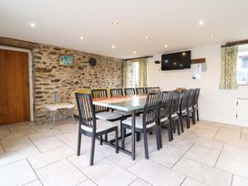 A dining room with a large table and chairs at Bwthyn Y Bugail (Shepherd's Cottage) Pedairffordd near Llanrhaeadr-Ym-Mochnant