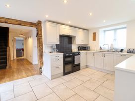 A kitchen with a stove, oven, and sink at Bwthyn Y Bugail (Shepherd's Cottage) Pedairffordd near Llanrhaeadr-Ym-Mochnant
