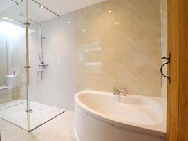 A bathroom featuring a bathtub, shower, and toilet at Bwthyn Y Bugail (Shepherd's Cottage) Pedairffordd near Llanrhaeadr-Ym-Mochnant