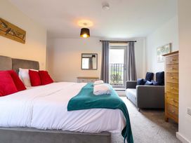 A bedroom with a bed and sofa at Bwthyn Y Bugail (Shepherd's Cottage) Pedairffordd near Llanrhaeadr-Ym-Mochnant