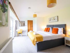 A bedroom with a bed and a mirror at Bwthyn Y Bugail (Shepherd's Cottage) Pedairffordd near Llanrhaeadr-Ym-Mochnant