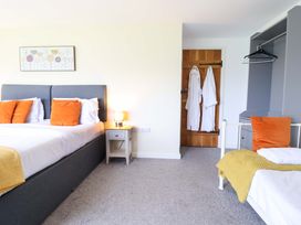 A bedroom with two beds and nightstand at Bwthyn Y Bugail (Shepherd's Cottage) Pedairffordd near Llanrhaeadr-Ym-Mochnant