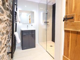A bathroom with a shower and sink at Bwthyn Y Bugail (Shepherd's Cottage) Pedairffordd near Llanrhaeadr-Ym-Mochnant